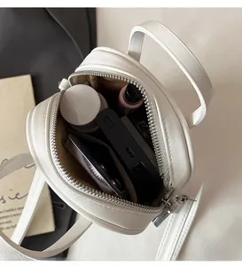 Detail view of white mini round handbag interior showing spacious storage for daily items