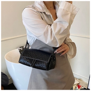 Vue détaillée du sac à bandoulière noir avec texture tissée et cuir synthétique mat