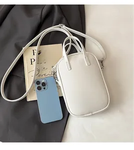 Mini white PU tote bag compared to a smartphone showing its compact size for daily use