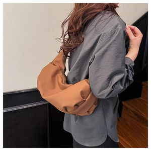 Detailed texture of brown hobo bag showing high-quality lychee grain and metal zipper