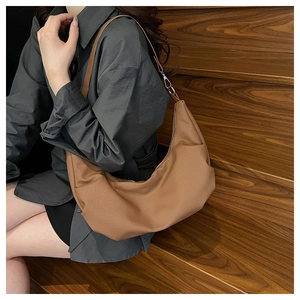 Detailed view of caramel leather large dumpling shoulder bag showing texture and strap