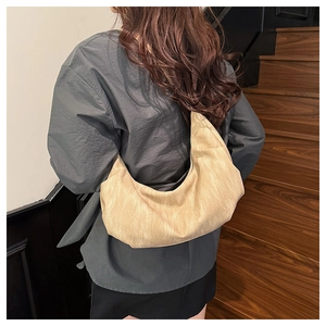 Detailed back view of a large beige leather slouchy bag on model for size and capacity