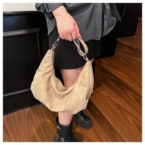 Detail of soft beige leather tote bag with elegant pleated texture and silver buckles