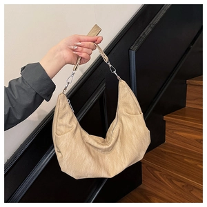 Detail of beige hobo bag showing pleated leather texture and silver hardware accents