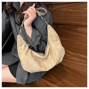 Detail view of cream soft leather hobo bag with pleated texture and silver hardware