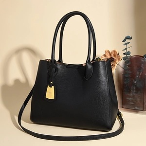 Classic black pebbled leather tote bag with gold kangaroo charm and adjustable strap