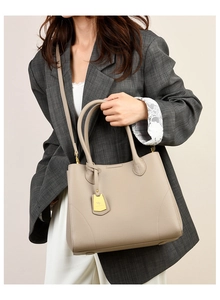 Detail of taupe tote bag with lychee texture and detachable shoulder strap on model