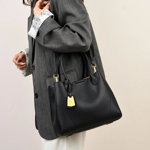 Close-up of black lychee grain leather tote bag with gold hardware and kangaroo logo tag