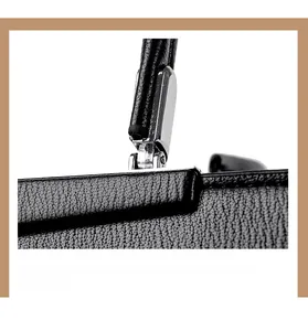 Vue détaillée de la texture du cuir noir et des attaches en métal argenté du sac à main