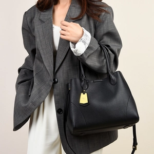 Detail of high-quality black lychee leather texture and golden metal kangaroo logo pendant