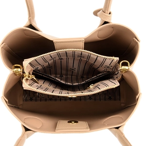 Detail showing internal compartments of the beige pebbled leather handbag with gold zipper