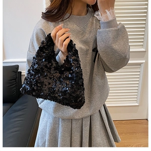 Fashionable black sequin underarm bag shown with a modern casual outfit