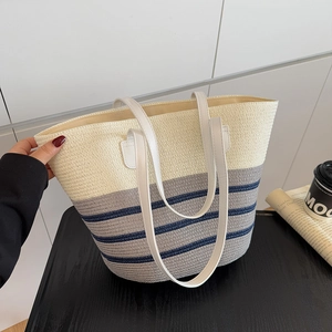 Large striped straw tote bag with faux leather handles for beach or travel use