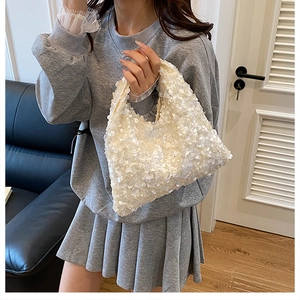 Close-up of sparkling white sequins on a stylish underarm bag in a lifestyle setting