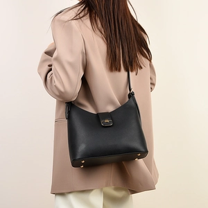 Detail of lychee pattern leather shoulder bag with gold rivets and metallic buckle
