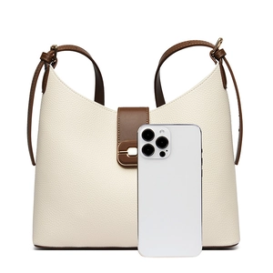 Detail view of large lychee grain leather bucket bag with contrast trim and metal buckle