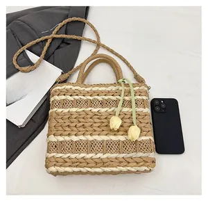 Detail of woven straw handbag with tulip charm, striped pattern and size comparison