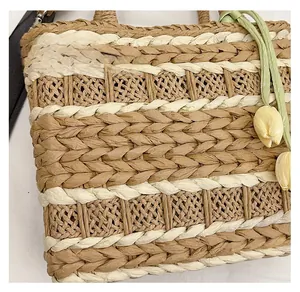 Detail of hand-woven straw bag with textured fiber pattern and tulip pendant ornament