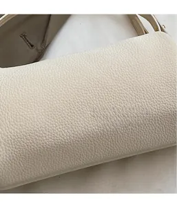 Macro detail of creamy white pillow bag featuring premium lychee grain leather texture