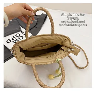 Internal view of beige straw bag showing zipper pocket and spacious khaki lining