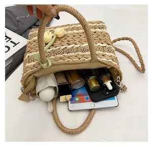 Detail shot showing a spacious interior of the straw bag with daily essentials inside