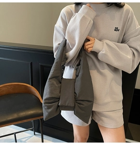 Detail of dark grey oversized bow handbag paired with waffle knit loungewear outfit