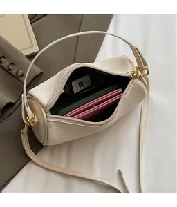 Detail view of cream cylinder bag interior showing ample space for phone and wallet