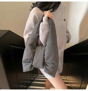 Detail of a large dark grey quilted tote bag featuring a decorative bow knot design