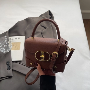 Brown lychee pattern leather handbag with gold oval twist lock and adjustable shoulder strap