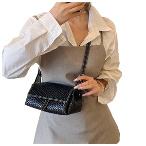 Sac bandoulière tissé noir avec coutures blanches porté par un mannequin