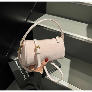 Macro shot of light pink barrel bag with lychee grain leather and gold hardware