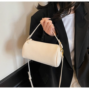 Detail of off-white lychee grain leather boston bag with golden hardware on model