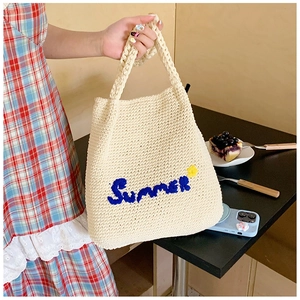 Detail of hand-woven off-white knit tote bag with Summer embroidery and star detail