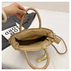 Detailed top view of straw tote interior featuring beige lining and zipper pockets