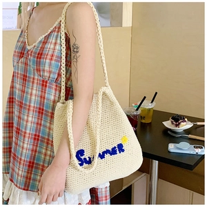 Detail of Summer embroidery and yellow flower on white hand-woven straw tote bag