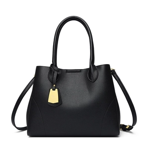 Minimalist black pebbled leather tote bag with gold kangaroo pendant and crossbody strap