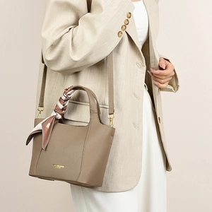 Detail of coffee brown lychee pattern leather tote with decorative silk scarf and gold hardware