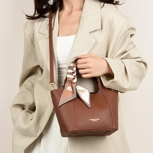 Detail of vintage brown pebble leather tote bag with printed silk scarf on the handle