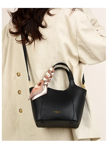 Detail of black litchi leather tote bag with gold logo and decorative printed silk scarf