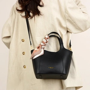 Close-up of black lychee leather tote bag with decorative silk scarf on model