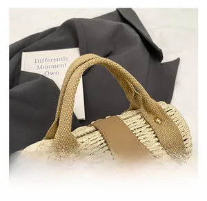 Close-up of woven straw handbag featuring canvas handles and a metal turn-lock closure