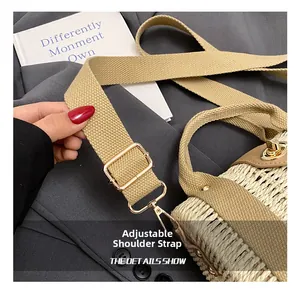 Close-up of adjustable canvas shoulder strap with gold buckle on woven beach bag
