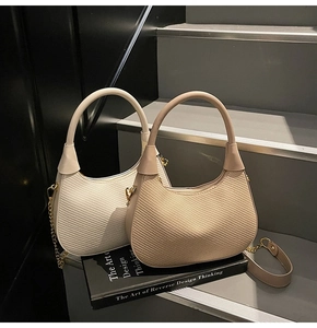 Close-up of woven texture on cream and beige hobo bags with metallic chain straps