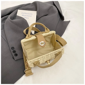 Detailed interior view of woven beige handbag with brown straps and metal turn-lock