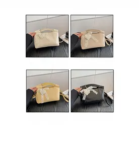 Detail view of bow pearl handbags in white, apricot, yellow and black options