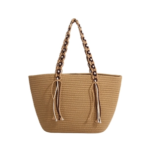 Large woven straw tote bag with braided handles and tassels in brown and white