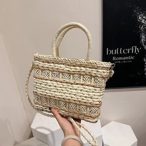 Two-tone straw tote bag with geometric woven patterns and a ring handle for summer travel