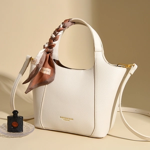 Large beige leather tote bag with silk scarf handle and golden hardware accent