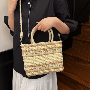 Chic straw woven handbag with round handles and shoulder strap for summer beach vacations