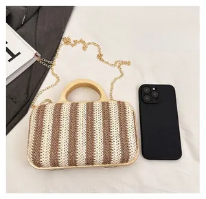 Detail of striped straw bag featuring wooden handle and size comparison with phone